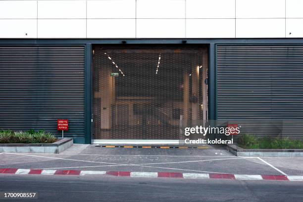 entrance of modern parking garage in tel aviv, israel - garagentor stock-fotos und bilder