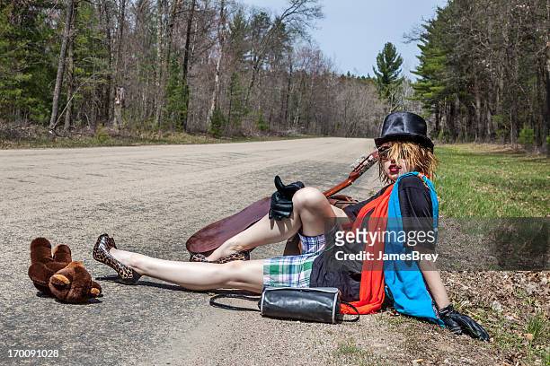 extraño hitchhiker girl thumbing para un viaje - car remote toy fotografías e imágenes de stock