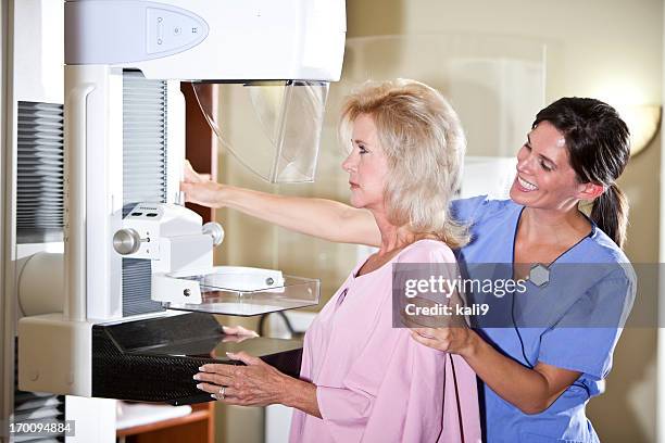 nurse with patient getting mammogram - mammogram stock pictures, royalty-free photos & images