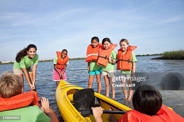 summer camp counselor and children with kayaks - summer camp canoe stock pictures, royalty-free photos & images