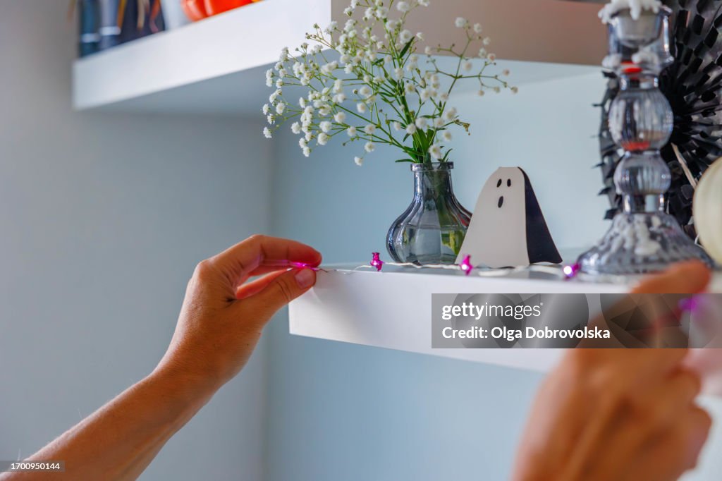 A close-up of the hands holding the Halloween garland