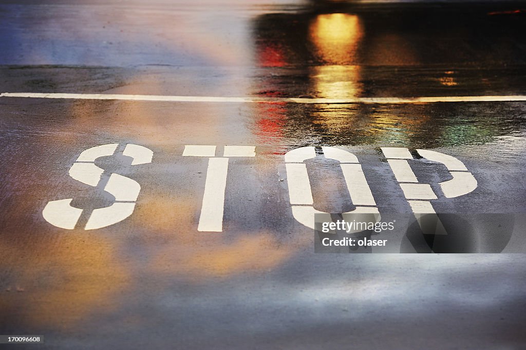 Road junction, stop Wort, motion verschwommen Auto in regnet