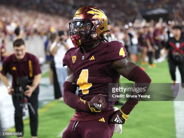 Demetries Ford of the Arizona State Sun Devils celebrates with Sun Devils fans after defending a pass in the endzone by pretending to put his samurai...