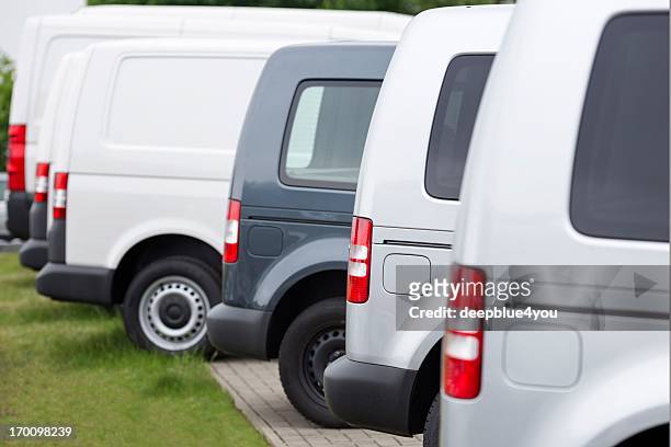 sideview of new vans in a row - compact car stockfoto's en -beelden