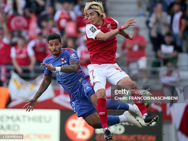 Lyon's Brazilian defender Henrique Silva Milagres fights for the ball with Reims' Japanese forward Junya Ito during the French L1 football match...