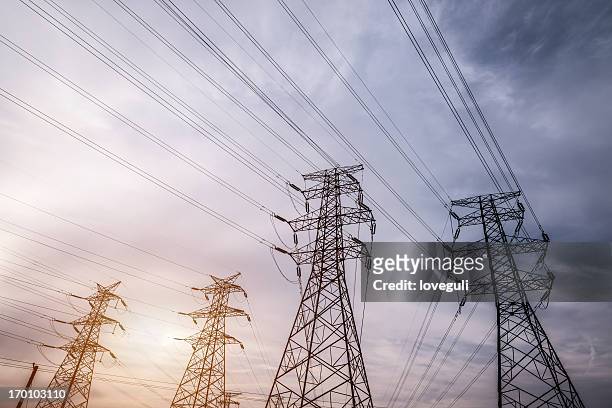 electricidad pylons - alto voltaje fotografías e imágenes de stock