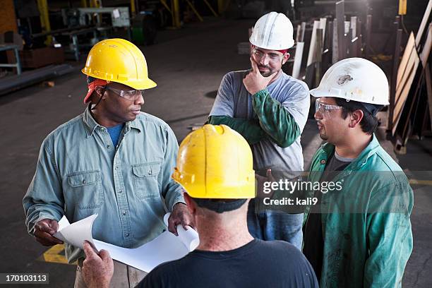 multi-ethnic workers in fabrication shop - four people talking stock pictures, royalty-free photos & images