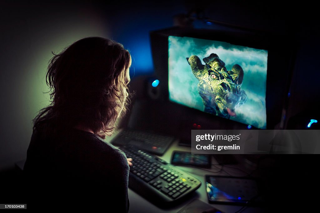 Addicted computer gamer playing late at night