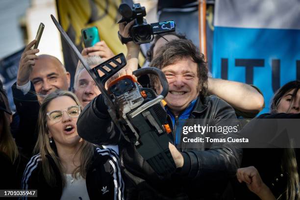 Presidential candidate Javier Milei of La Libertad Avanza lifts a chainsaw next to Buenos Aires province governor candidate Carolina Piparo of La...