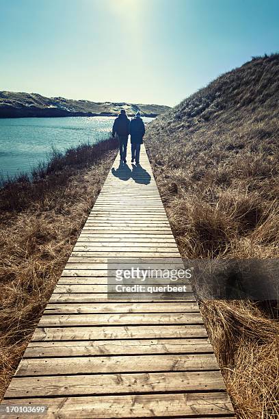 couple marchant dans les dunes - foehr island photos et images de collection