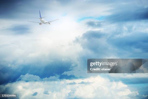 sunlit airplane flying against dramatic sky - air cargo stock pictures, royalty-free photos & images
