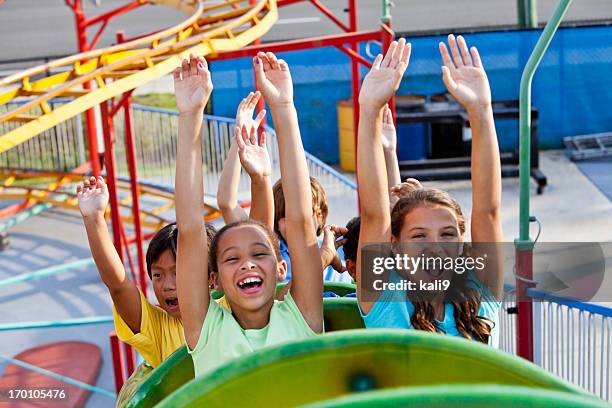 children riding a roller coaster - joy ride stock pictures, royalty-free photos & images