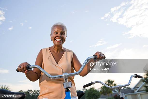 senior african american woman with bicycle - black woman riding bike stock pictures, royalty-free photos & images