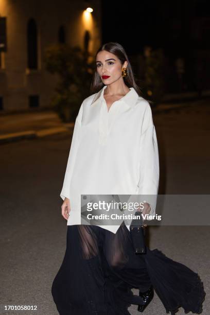 Olivia Culpo wears white oversized button shirt Khaite, black pleated transparent long skirt Khaite, black boots, Hermes bag during the Milan Fashion...