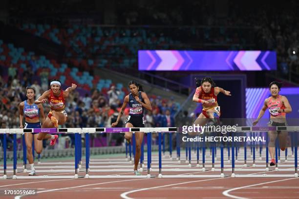 China's Lin Yuwei and China's Wu Yanni compete in the women's 100m hurdles final athletics event during the 2022 Asian Games in Hangzhou in China's...
