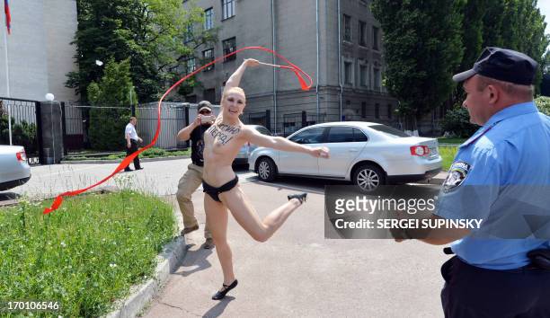 An activist of the women's feminist organization Femen, with the word "Forward Russia !" written on her torso, shouts "Vladimir I love you!" performs...