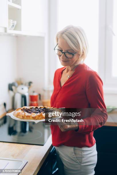 senior woman baking a pie - making a cake stock pictures, royalty-free photos & images