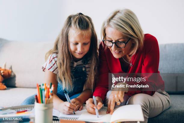 happy grandmother and granddaughter spending quality time drawing together at home - school closing stock pictures, royalty-free photos & images