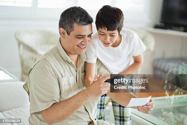 padre e hijo los depósitos a través de banco múltiple - bank deposit slip fotografías e imágenes de stock