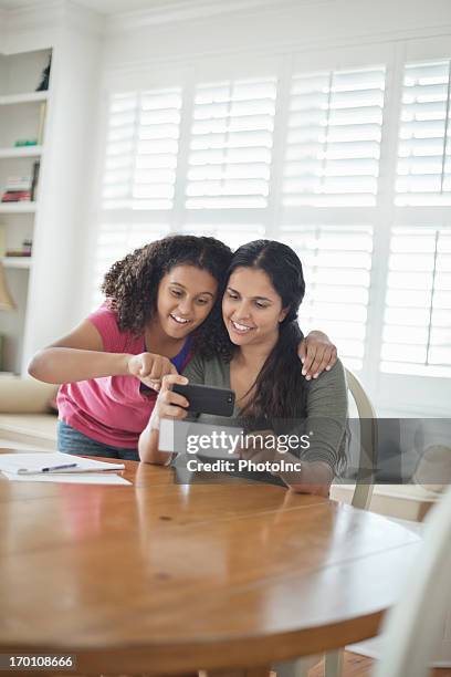 hija y madre de depositar bank plaza a través de teléfono - bank deposit slip fotografías e imágenes de stock