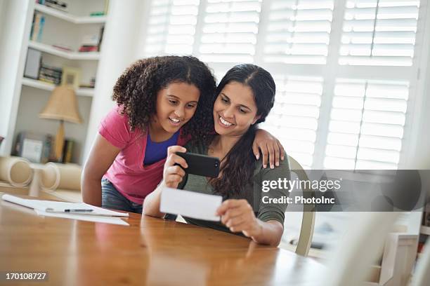 hija y madre de depositar bank plaza a través de teléfonos móviles. - bank deposit slip fotografías e imágenes de stock