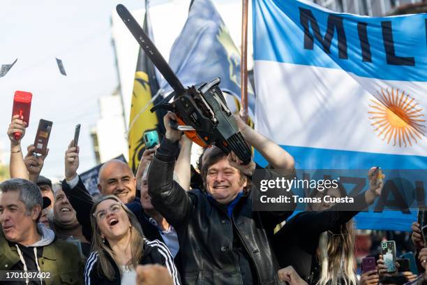 Presidential candidate Javier Milei of La Libertad Avanza lifts a chainsaw next to his candidate to Buenos Aires Province governor, Carolina Piparo...