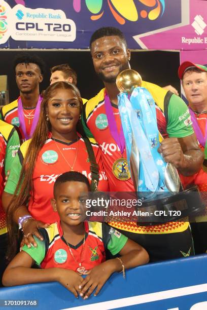 Romario Shepherd, of Guyana Amazon Warriors, along with his family pose for a photo with the Republic Bank Caribbean Premier League Trophy after...
