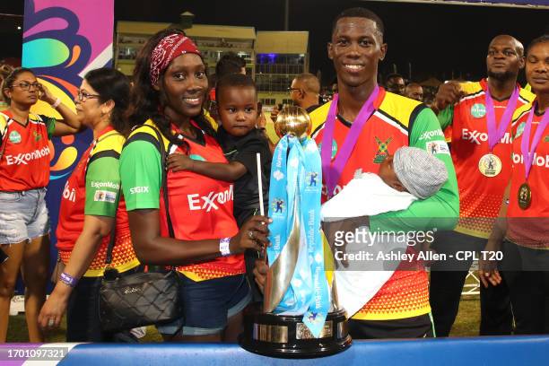 Kevlon Anderson, of Guyana Amazon Warriors, along with his family pose for a photo with the Republic Bank Caribbean Premier League Trophy after...