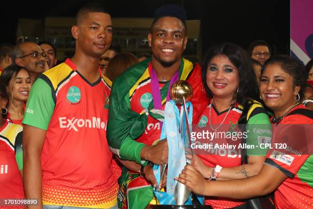 Shimron Hetmyer, of Guyana Amazon Warriors, along with his family pose for a photo with the Republic Bank Caribbean Premier League Trophy after...