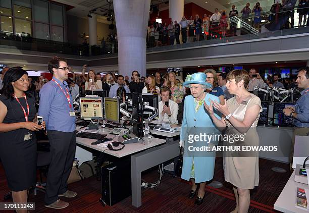 Britain's Queen Elizabeth II visits BBC news room as as she officially opens the corporation's new headquarters in London on June 7, 2013. Queen...