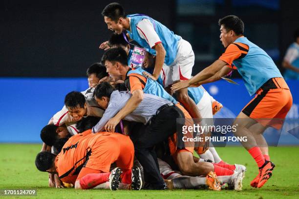 North Korea's Kim Kukbom celebrates with his team after scoring a goal at the men's quarter-final football match between North Korea and Japan during...