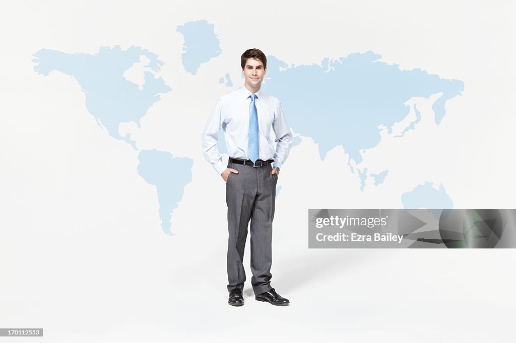 Businessman standing with world map.