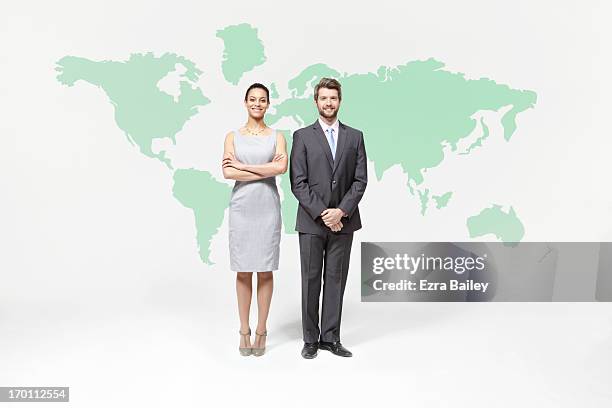 businessman and woman standing with world map. - woman in suit stock pictures, royalty-free photos & images
