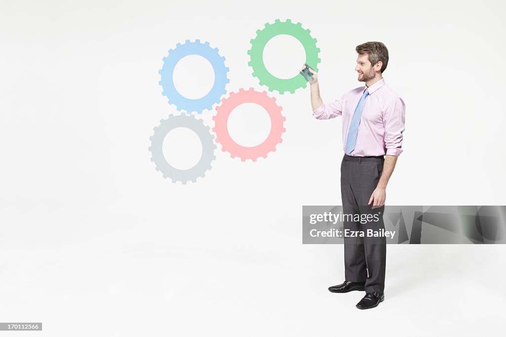 Businessman completing a system of cogs.