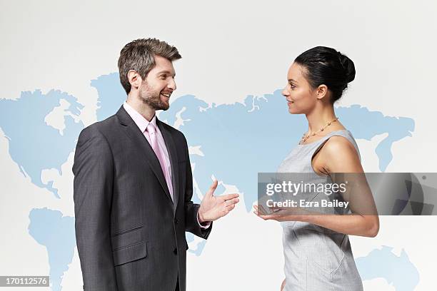 business people chatting in front of world map. - deal england - fotografias e filmes do acervo