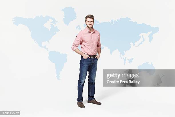 man in casual clothes standing with world map. - hände in den taschen stock-fotos und bilder