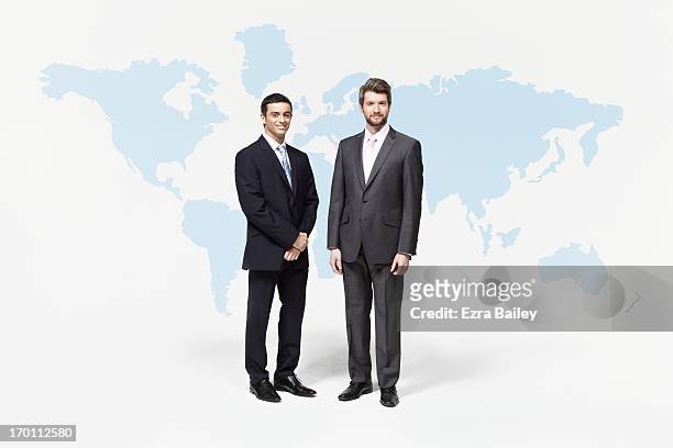 businessmen standing in front of world map - suit and tie stock pictures, royalty-free photos & images