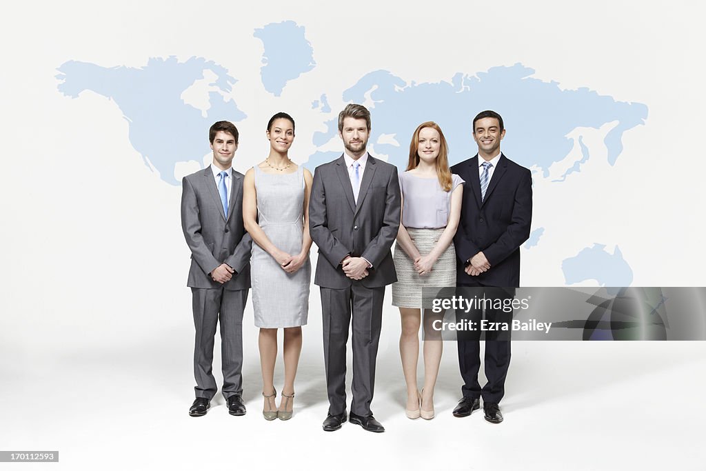 Group of business people standing with world map.