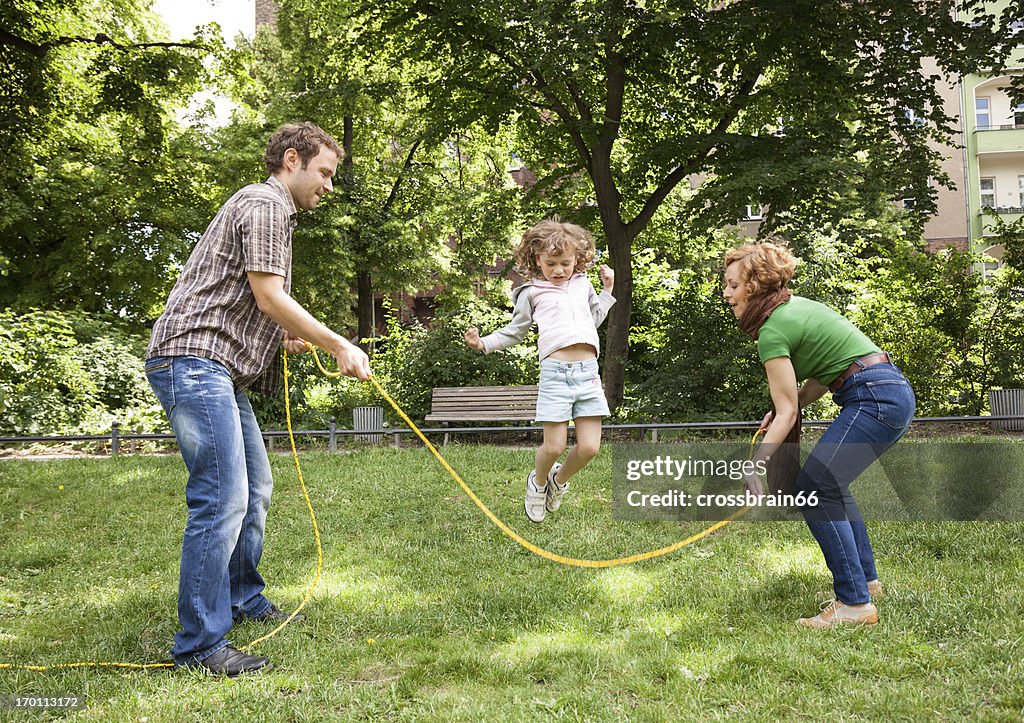 Familie spielen im Freien-Junge Mädchen Springseil