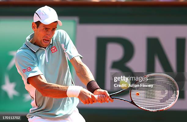 Novak Djokovic of Serbia plays a backhand during the men's singles semi-final match against Rafael Nadal of Spain on day thirteen of the French Open...