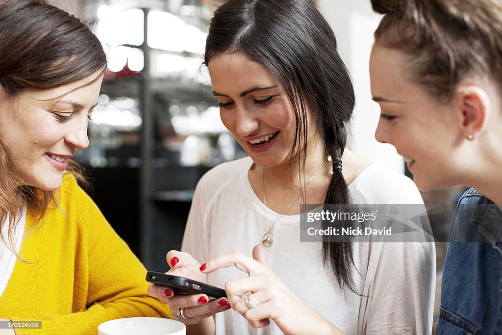 Female friends enjoying time together looking at a smart phone