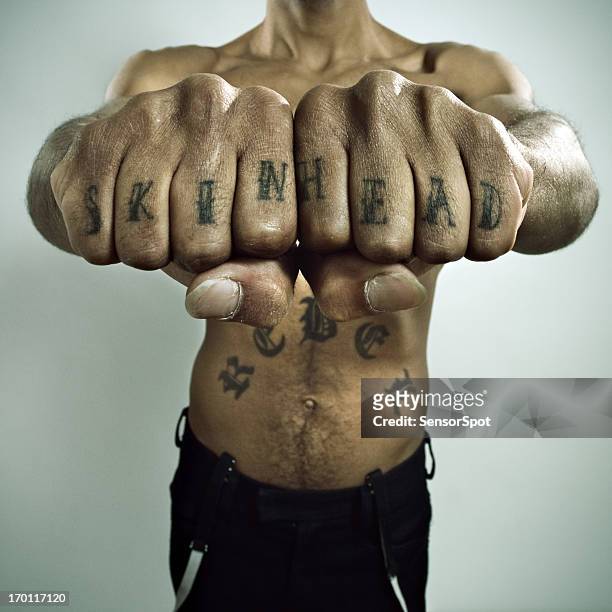 skinhead showing off knuckle tattoo - knuckle stock pictures, royalty-free photos & images