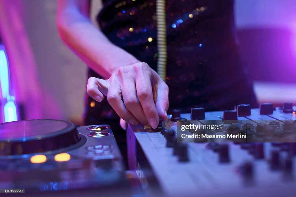 Female DeeJay with turntable and soundboard.