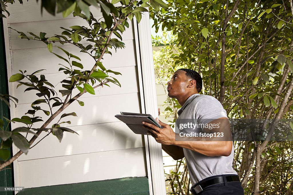 Casa inspeção no exterior. Usando o tablet digital para registrar os resultados