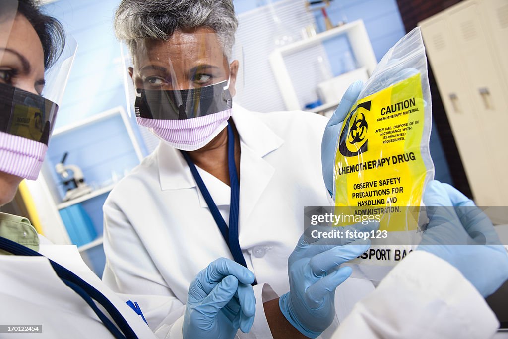 Multi-ethnic doctors discussing medical contents of chemotherapy bag