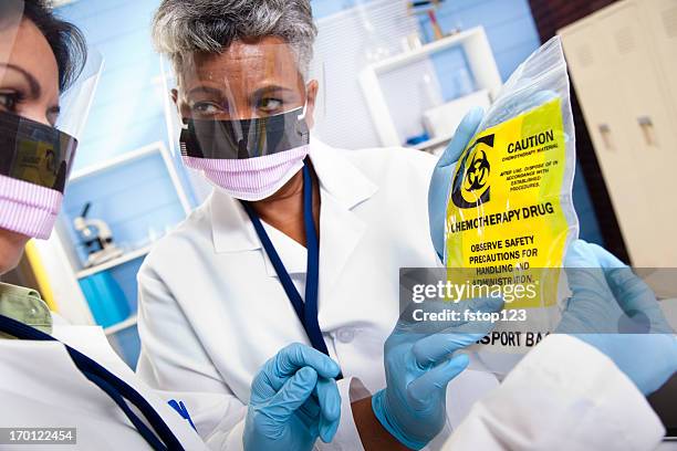 multi-ethnic doctors discussing medical contents of chemotherapy bag - chemotherapy drug stock pictures, royalty-free photos & images