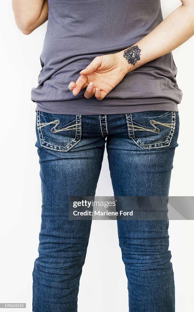 Woman with fingers crossed behind back