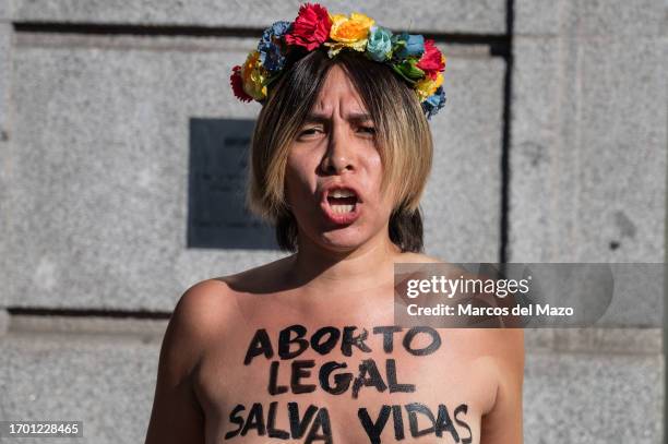An activist of feminist group FEMEN with heir bare chest painted with a messages reading "legal abortion saves lives", protesting in front of the...