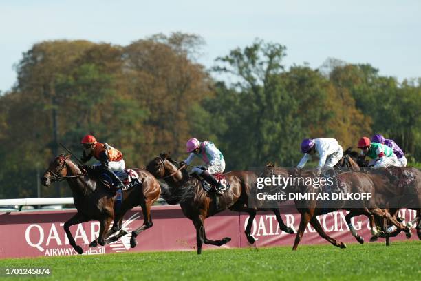 Italian jockey Cristian Demuro riding Favourite Ace Impact races to cross the finish line to win the Qatar Prix de l'Arc de Triomphe horse race at...