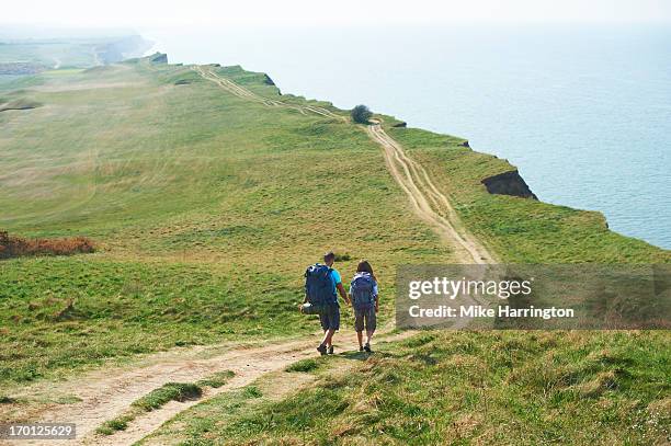 male and female walking along path on cliff top - características do litoral - fotografias e filmes do acervo